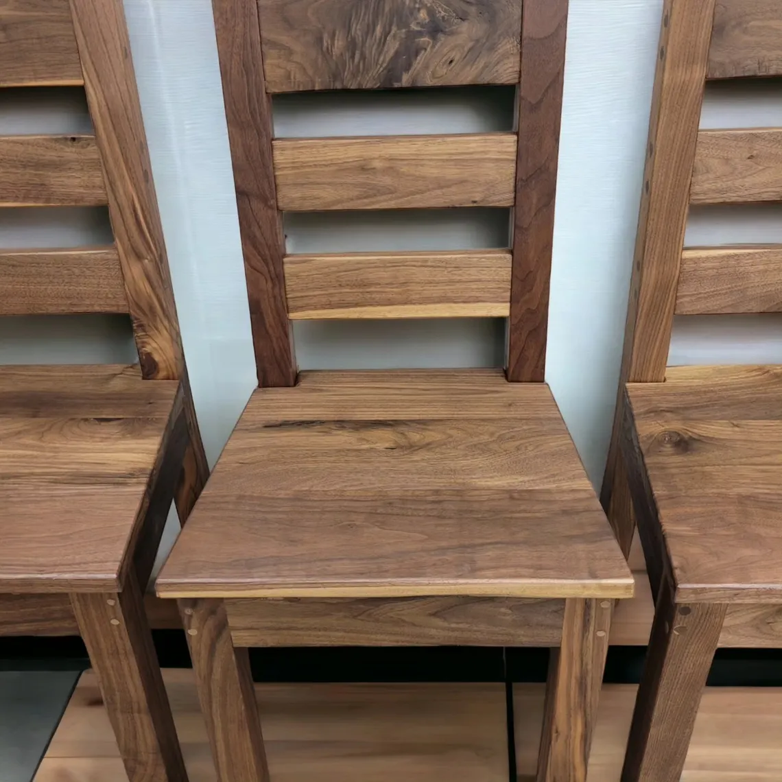 Close view of a solid walnut dining chair with a slatted back
